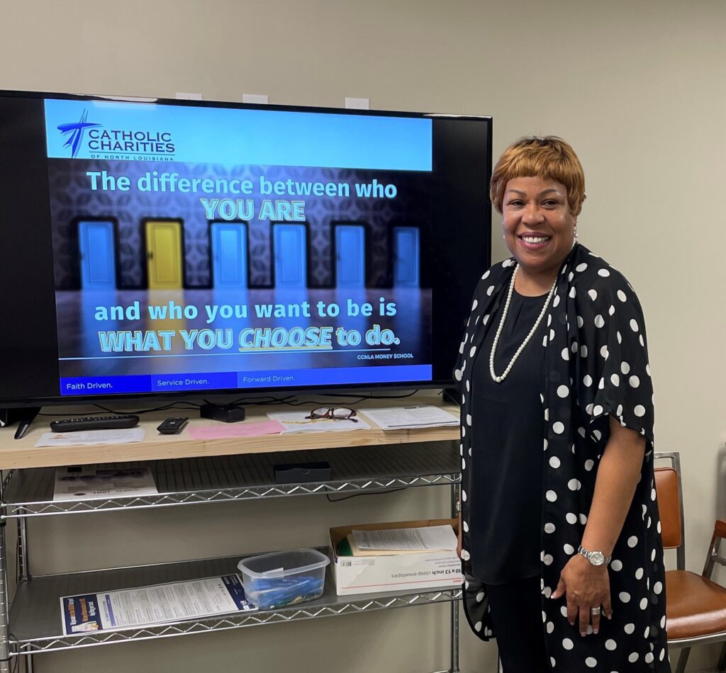 jean woods stands in front of a tv in the shreveport ccnla office with a graphic that reads "the difference between who you are and who you want to be is what you choose to do"